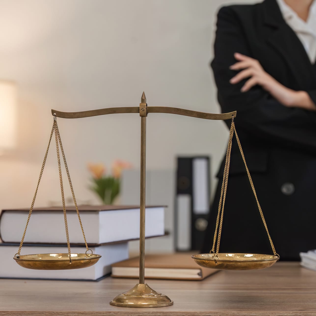 Law justice scales with attorney in background